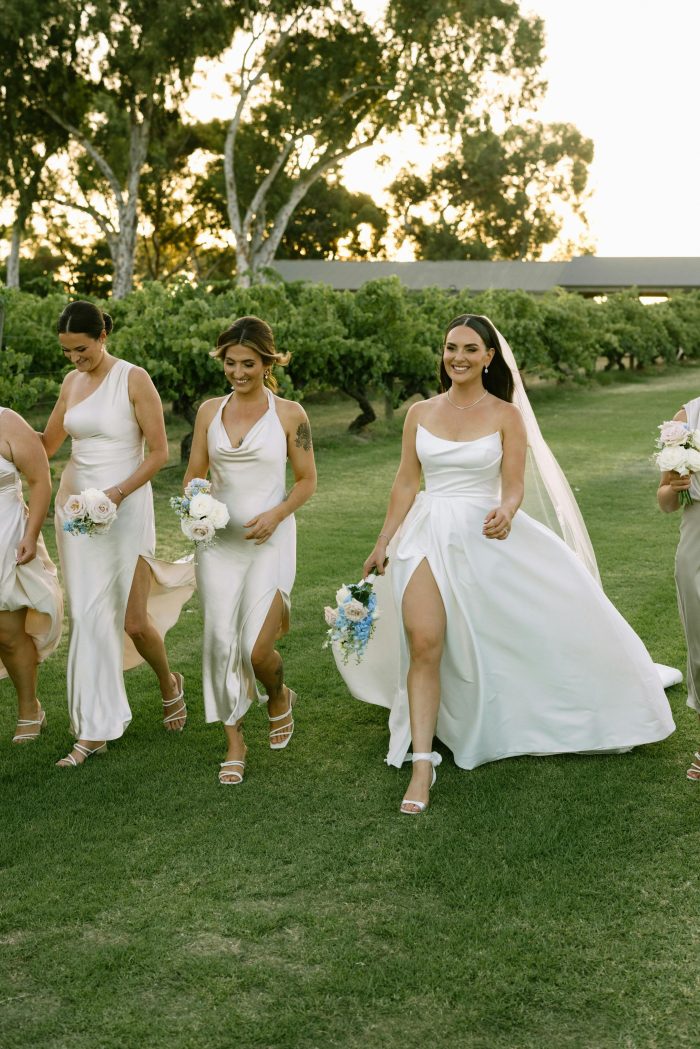 Bride wearing Aspen by Sottero and Midgley with her bridesmaids in champagne bridesmaid dresses