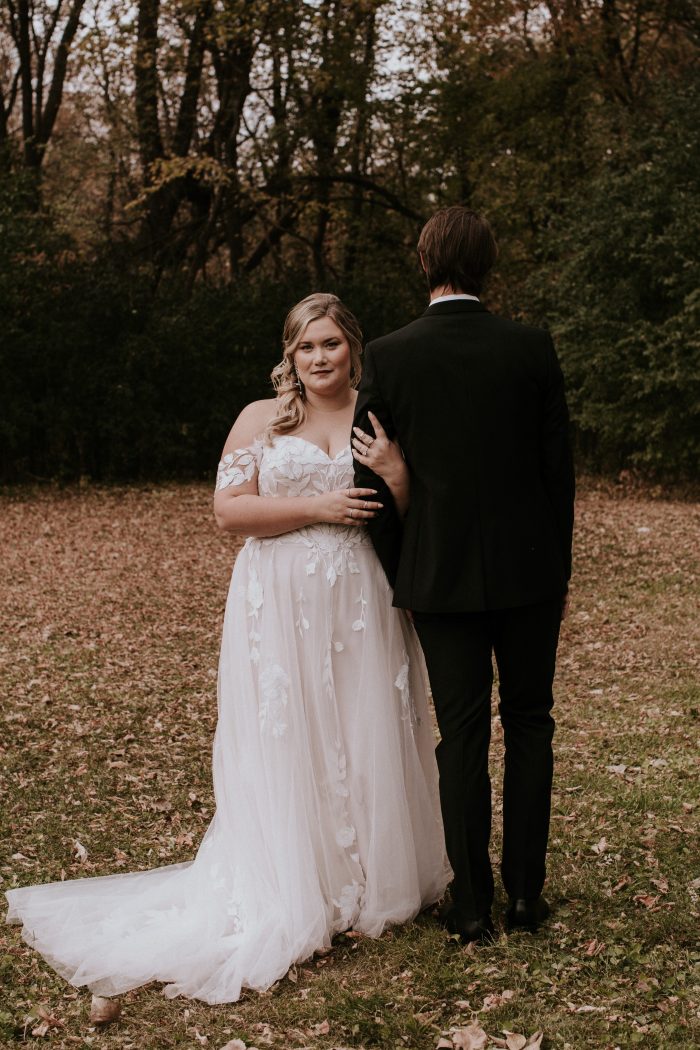 Blonde Bride In Off-The-Shoulder Wedding Dress Called Hattie Lane Lynette By Rebecca Ingram With Groom In Black Suit
