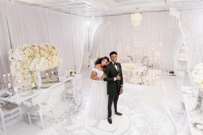 Groom Standing with Bride at an Elysian Wedding Reception Decorated by Black Wedding Vendors