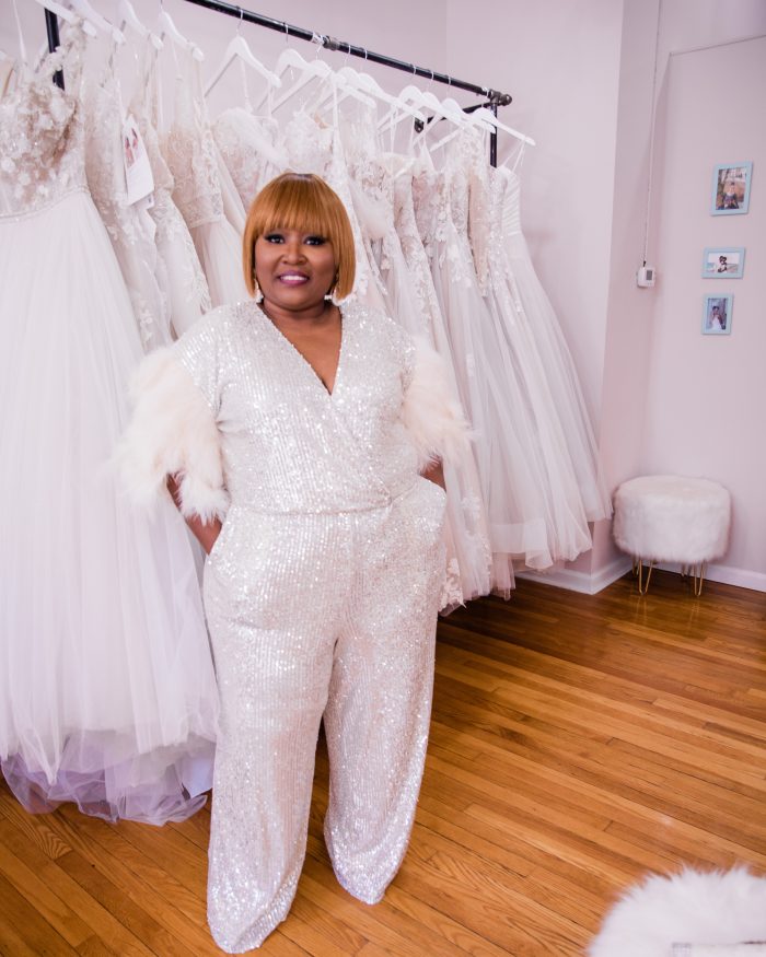 Photo Of Black Retailer Named LaTonya Turnage Owner Of Elite Secrets Bridal Standing In Front Of Maggie Sottero Wedding Dresses
