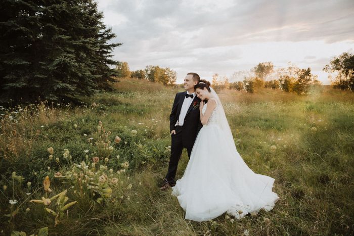 Bride Wearing Ball Gown Wedding Dress and Resting Head on Groom's Shoulder