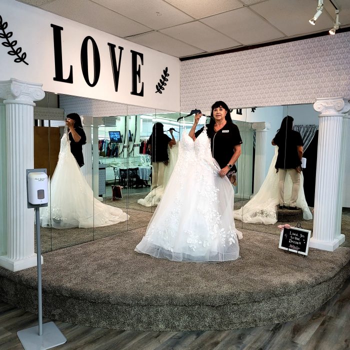 Jae-Geo Bridal and Tuxedo Boutique Owner Holding A Wedding Dress
