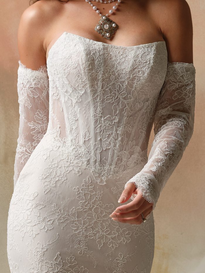 Close-up of detachable lace sleeves featuring delicate floral embroidery and scalloped edges, paired with a strapless lace wedding dress. The sheer fitted sleeves add a romantic, vintage-inspired touch to the bridal look.