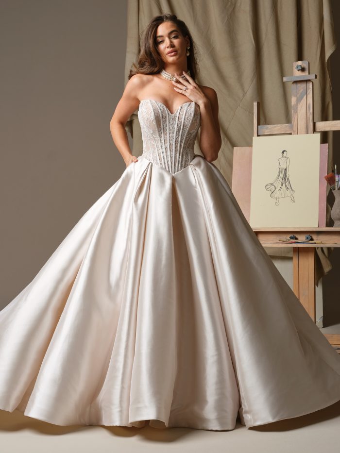 Ashland by Maggie Sottero strapless ball gown wedding dress in Elin stretch Mikado featuring a sheer Chantilly lace bodice with exposed boning and a full skirt