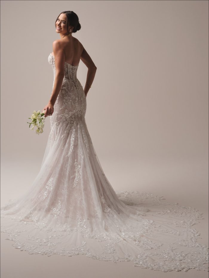 Back view of the Benjie Royale mermaid bridal gown showing the extended illusion scalloped lace train with sequin and beaded lace motifs, covered button detail, and glittering Chantilly layers for a dramatic aisle moment.