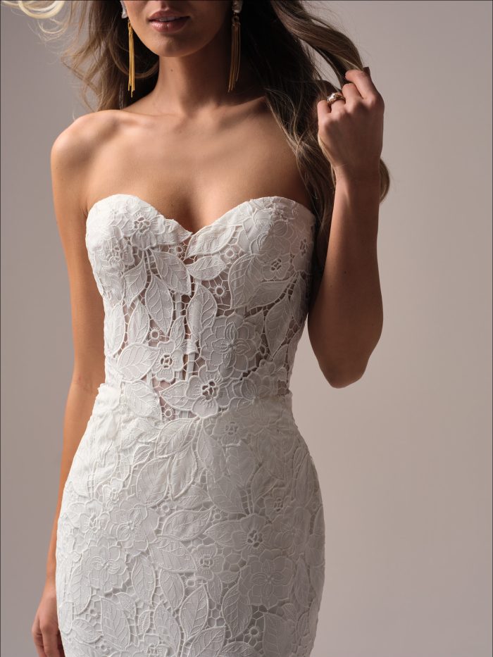 Close-up of the Dakota wedding dress highlighting the sweetheart neckline, sheer lace corset bodice, and intricate allover floral lace texture on a fitted silhouette.