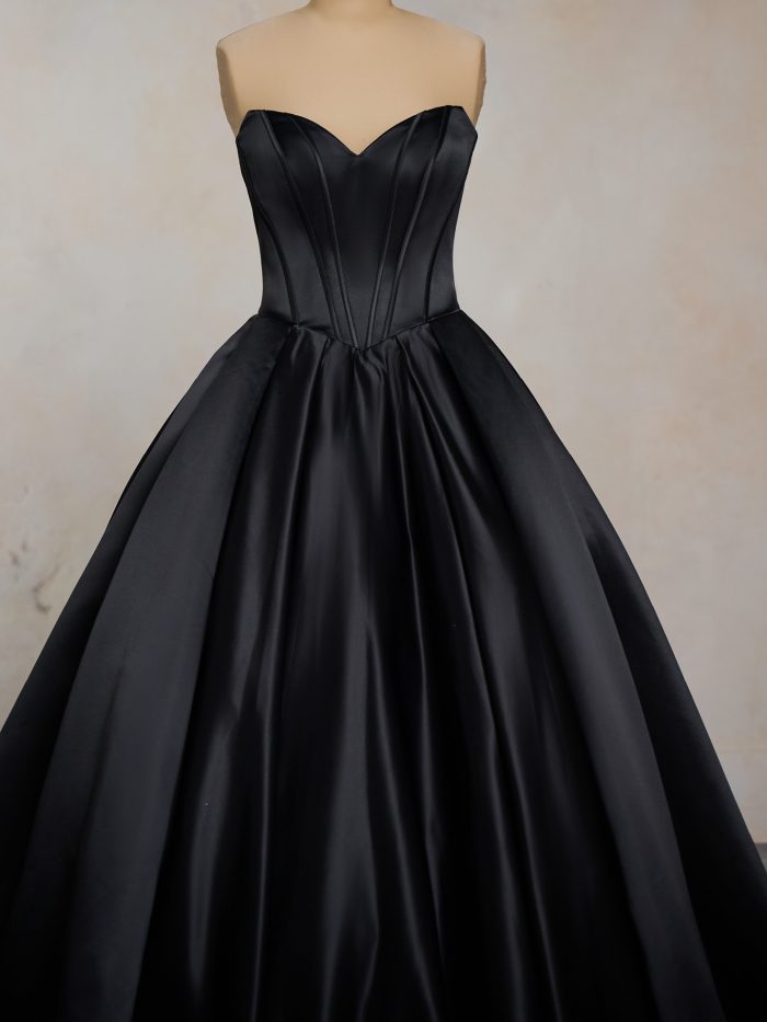 Close-up of Derrick black ballgown wedding dress by Maggie Sottero featuring structured corset bodice with exposed boning and sweetheart neckline, paired with full satin skirt.