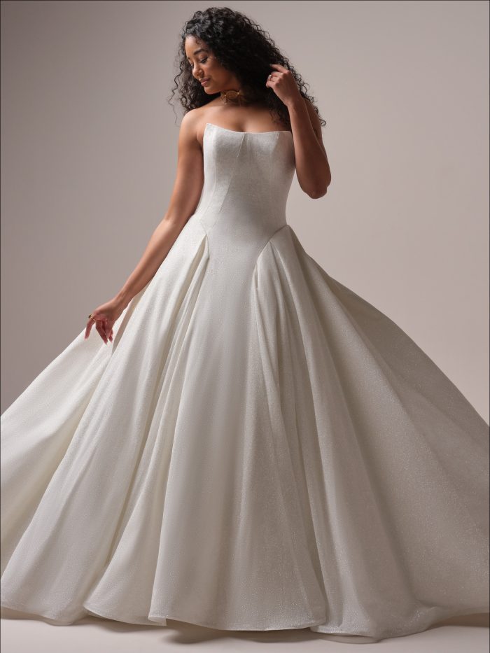 Bride wearing the Maggie Sottero Fortune Royale ballgown wedding dress featuring a strapless square neckline, structured bodice, and shimmering jacquard fabric that flows into a voluminous skirt.