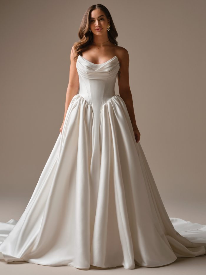 Hudson by Maggie Sottero satin ballgown wedding dress with a draped bodice, sculpted waist, and signature cat-eye neckline