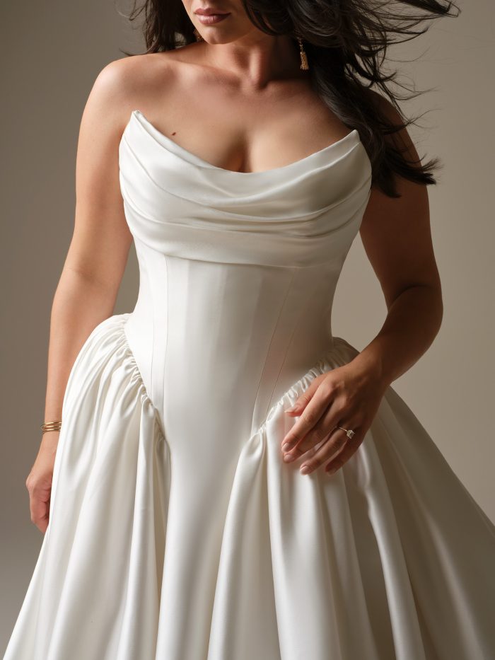 Close-up of Maggie Sottero Hudson satin ballgown wedding dress featuring draped strapless corset bodice and structured waistline