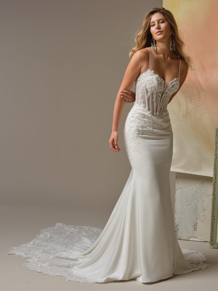Bride wearing the India sheath wedding dress by Maggie Sottero, featuring a lace corset bodice with delicate spaghetti straps, exposed boning, and a sleek fitted skirt.