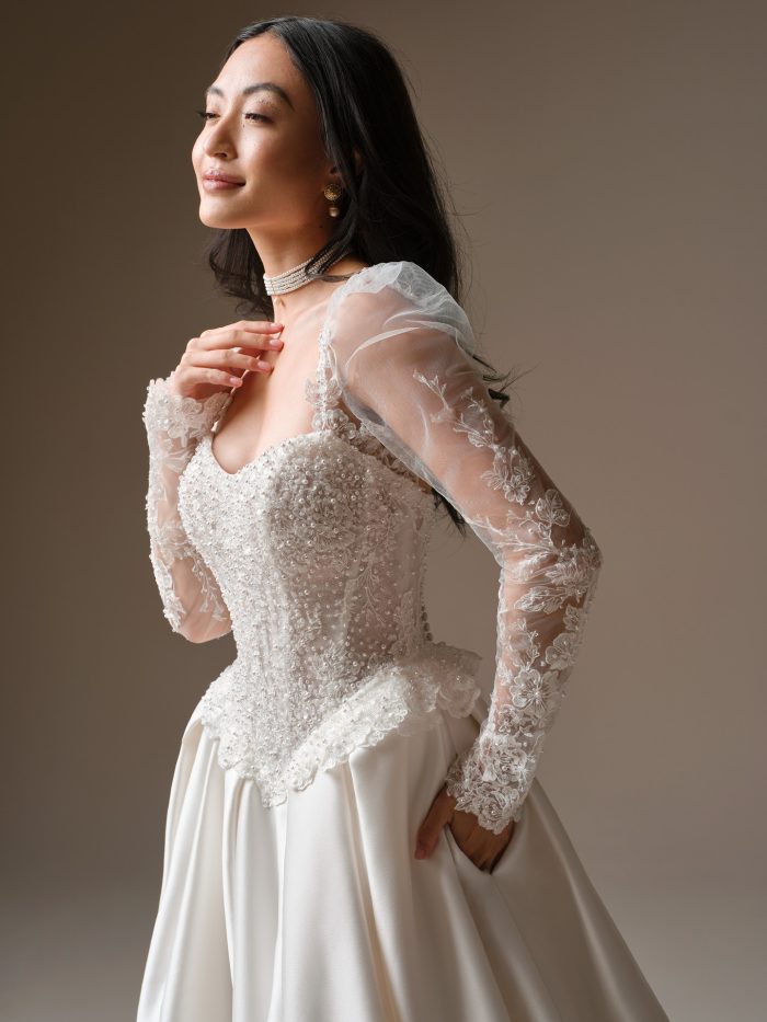 Maggie Sottero London ballgown wedding dress featuring beaded lace corset bodice with sheer long sleeves and sweetheart neckline