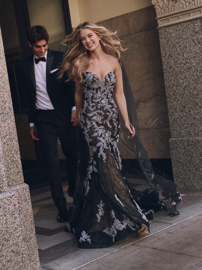 Front view of Peony black fit-and-flare wedding dress by Maggie Sottero featuring strapless sweetheart neckline, lace appliqués, and sheer black veil, styled with romantic sparkle.