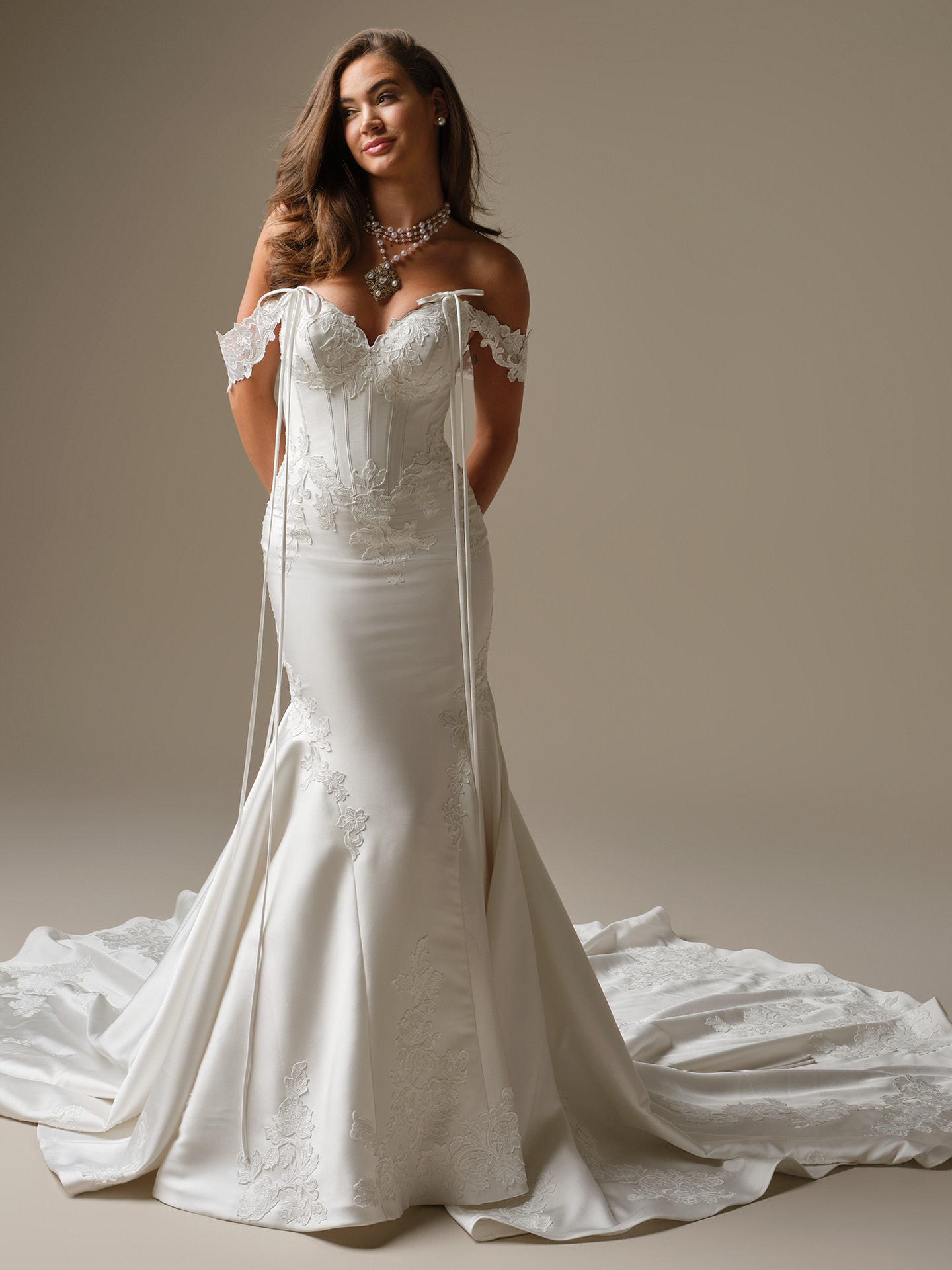 Serafina Lane fit-and-flare wedding dress featuring intricate lace appliqués, exposed corset bodice, off-the-shoulder straps, and sweeping lace train.