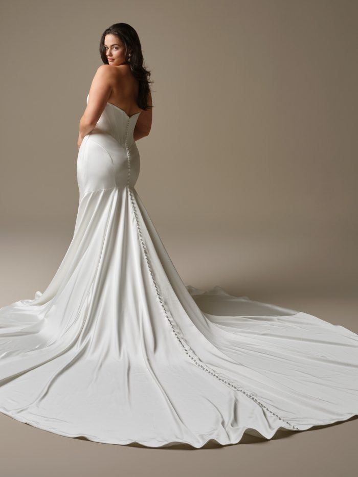 Sinclaire satin fit-and-flare wedding dress with strapless corset bodice, covered button back, and dramatic extended train.