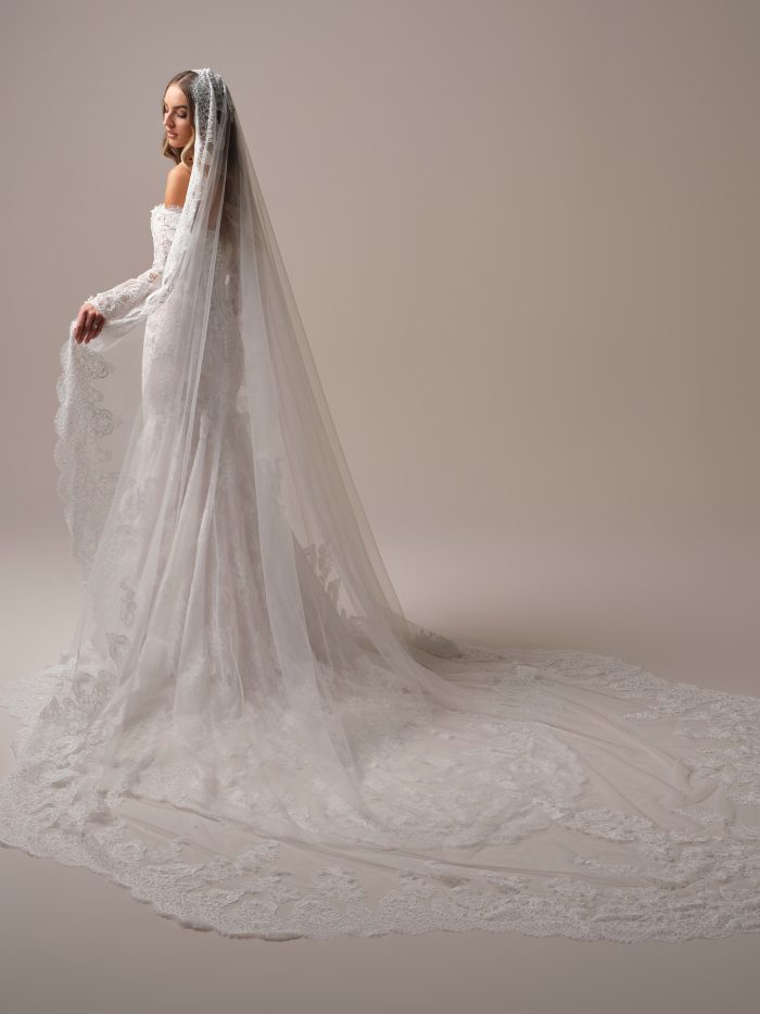 Back view of the Takera veil by Maggie Sottero, showcasing its dramatic royal-length train with ornate Chantilly lace motifs and scalloped lace borders.