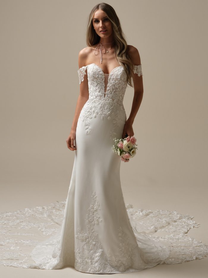 Bride wearing the Yara sheath wedding dress by Maggie Sottero, featuring an illusion strapless sweetheart neckline, delicate floral lace bodice, and fitted crepe skirt with lace train.