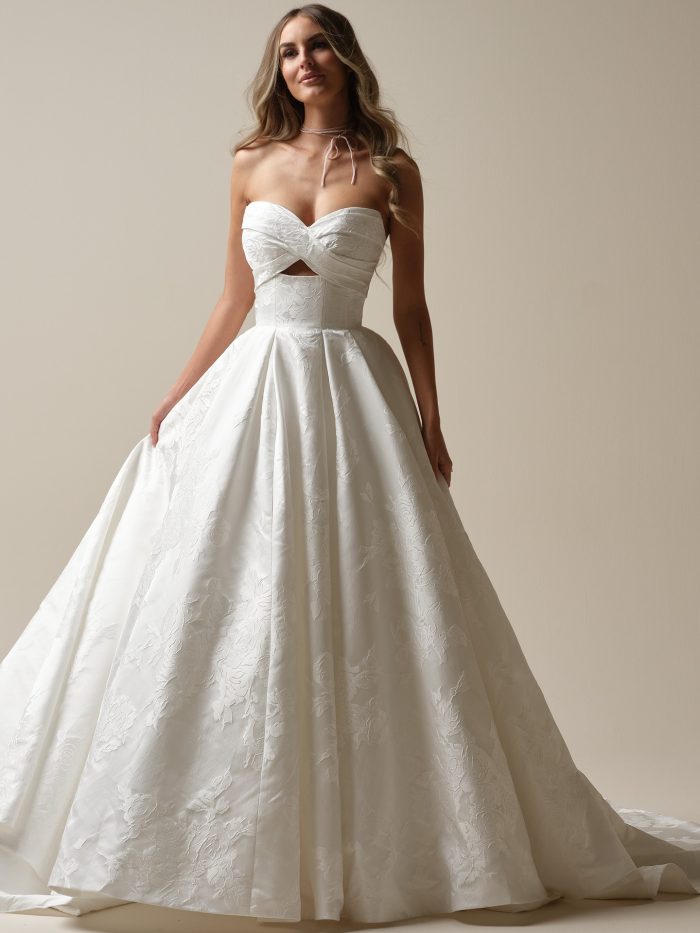 Maggie Sottero Zinaida Marie ballgown wedding dress featuring a strapless sweetheart neckline with twisted bodice detail, chic cutout, and jacquard-inspired floral fabric.