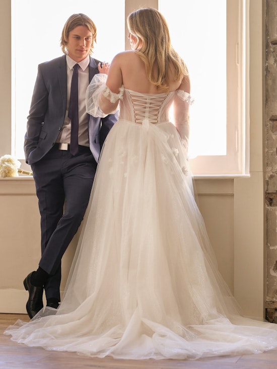 Bride looking at groom wearing a white A-line wedding dress with a lace up corset.
