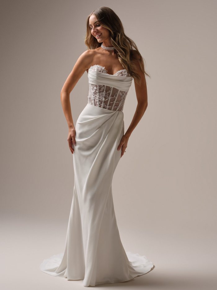 Bride in a sleek floral lace and crepe sheath wedding dress featuring a sheer corset bodice, sweetheart neckline, and softly draped skirt with a clean, modern silhouette.