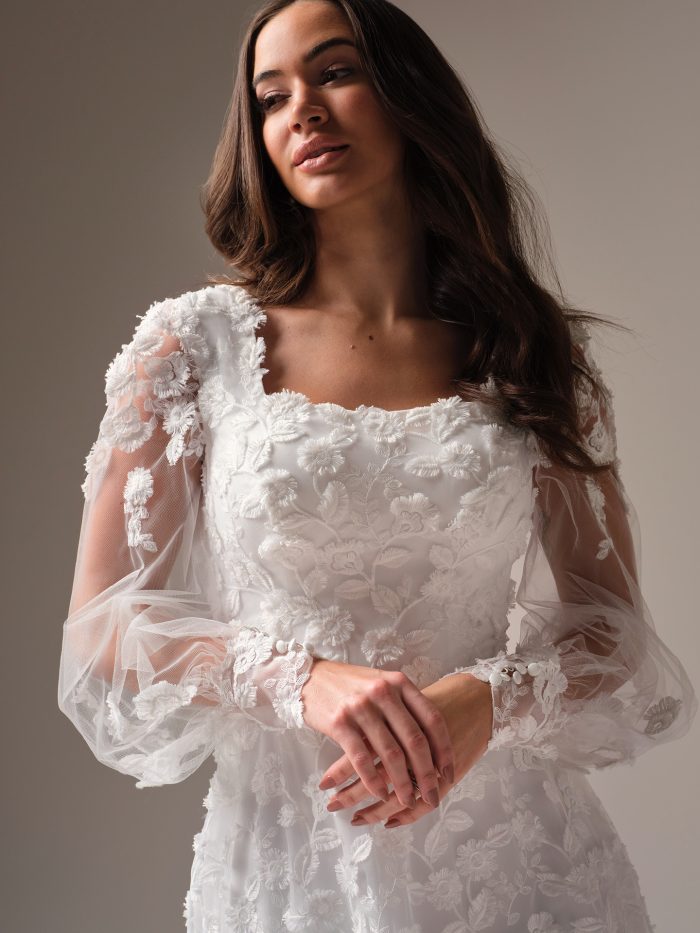 Bride wearing an allover lace wedding dress with a square neckline and illusion long sleeves