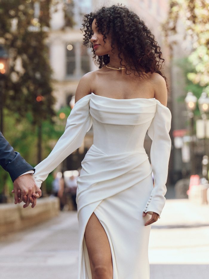 Bride wearing a modern off-the-shoulder crepe wedding gown with a high slit