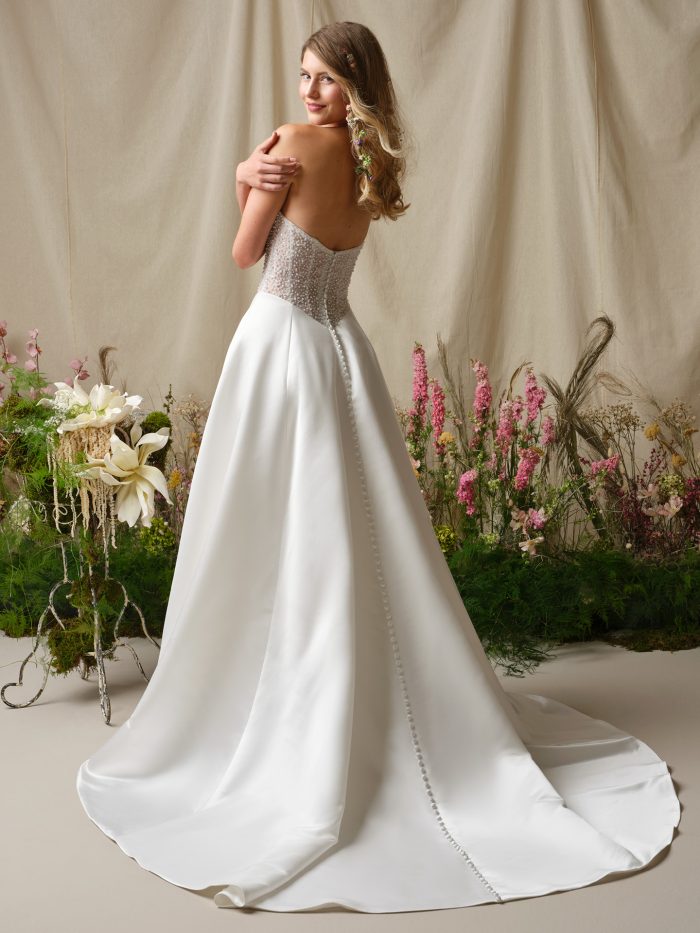 Marty A-line wedding dress with a strapless beaded bodice, satin button down train, and full satin skirt captured in a soft studio backdrop.