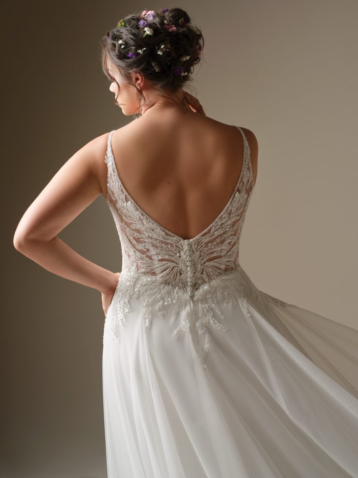 Back view of Valarie by Rebecca Ingram featuring a deep V-back with beaded lace details, delicate straps, and covered buttons over a flowing tulle skirt.