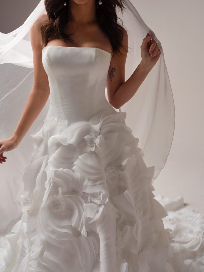 Bride wearing a ballgown wedding dress with a low waist and ruffled skirt