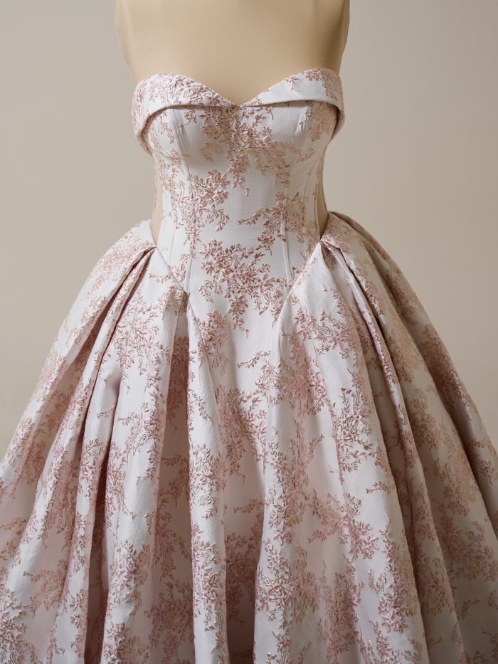 Sottero and Midgley Aberdeen ballgown wedding dress in blush featuring a strapless sweetheart neckline, structured corset bodice, and full pleated skirt with delicate rose floral jacquard detailing.