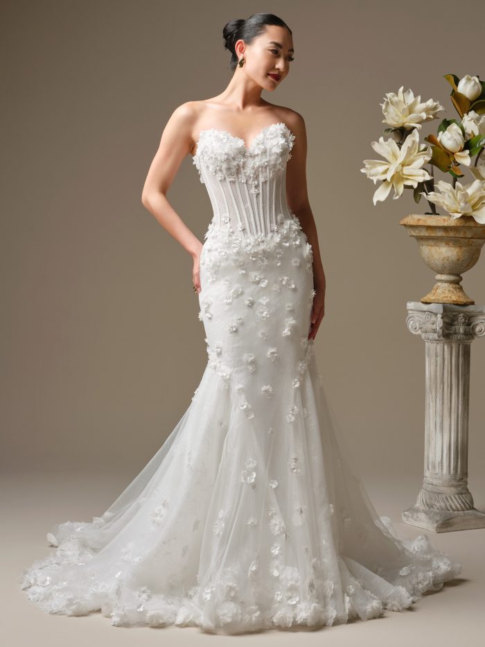 Front view of the Akari fit-and-flare wedding dress featuring exposed corsetry, dimensional white floral appliqué, and a softly flared tulle skirt.