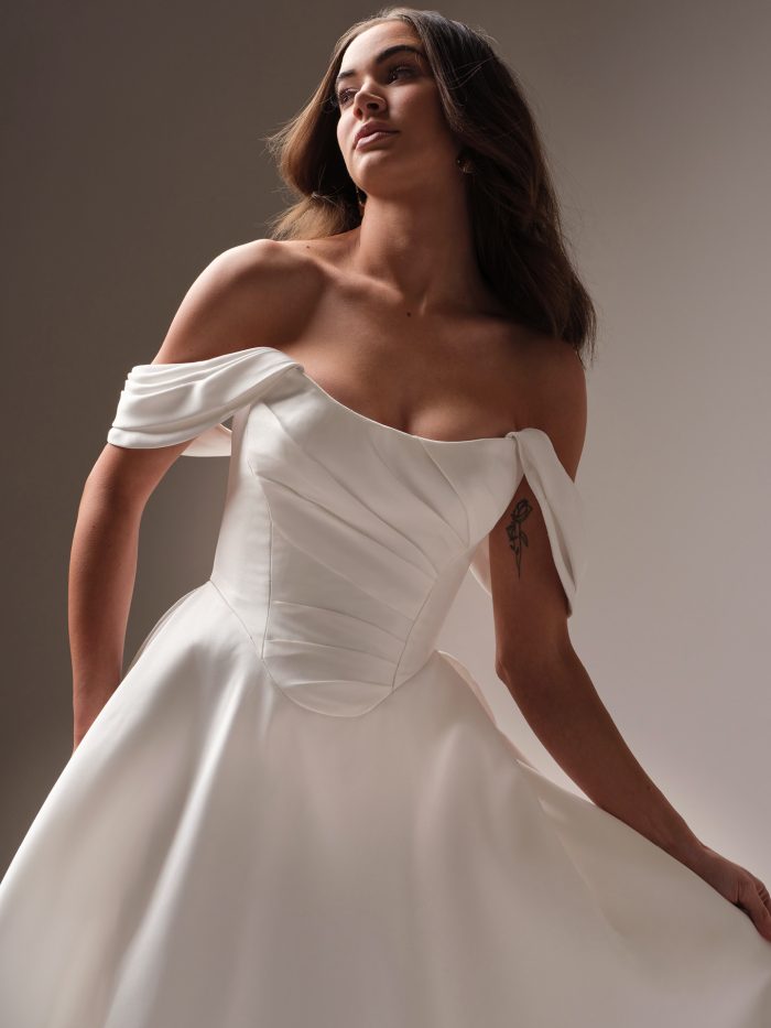 Bride wearing a simple wedding gown with a basque waist