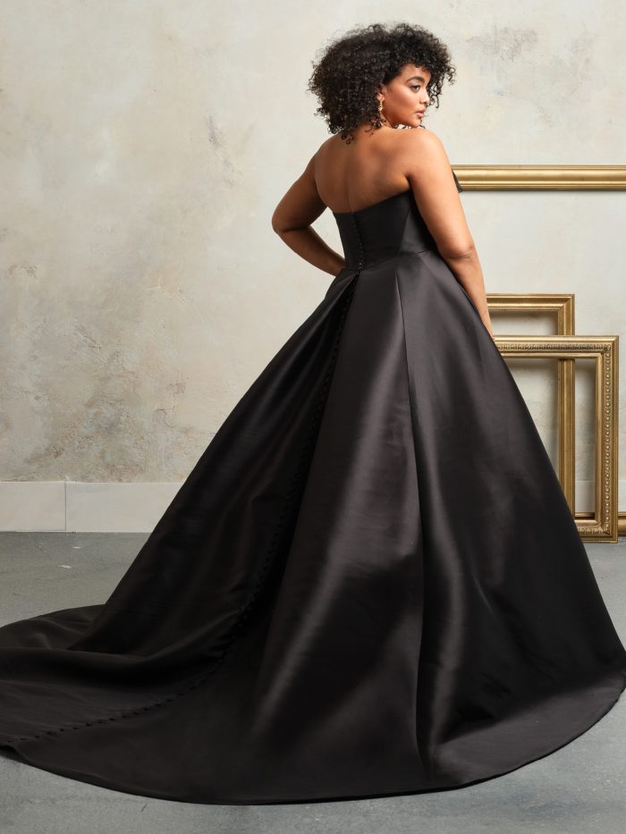 Back view of Faro black ballgown wedding dress by Sottero and Midgley featuring strapless bodice, covered buttons, and sweeping chapel-length train in sleek satin fabric.