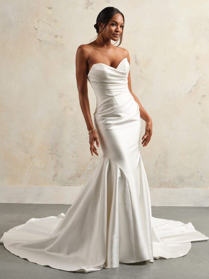 Bride wearing the Sottero and Midgley Giselle fit-and-flare wedding dress in Cartago satin, featuring an asymmetrical draped bodice, strapless sweetheart neckline, and sleek modern silhouette with flared skirt.