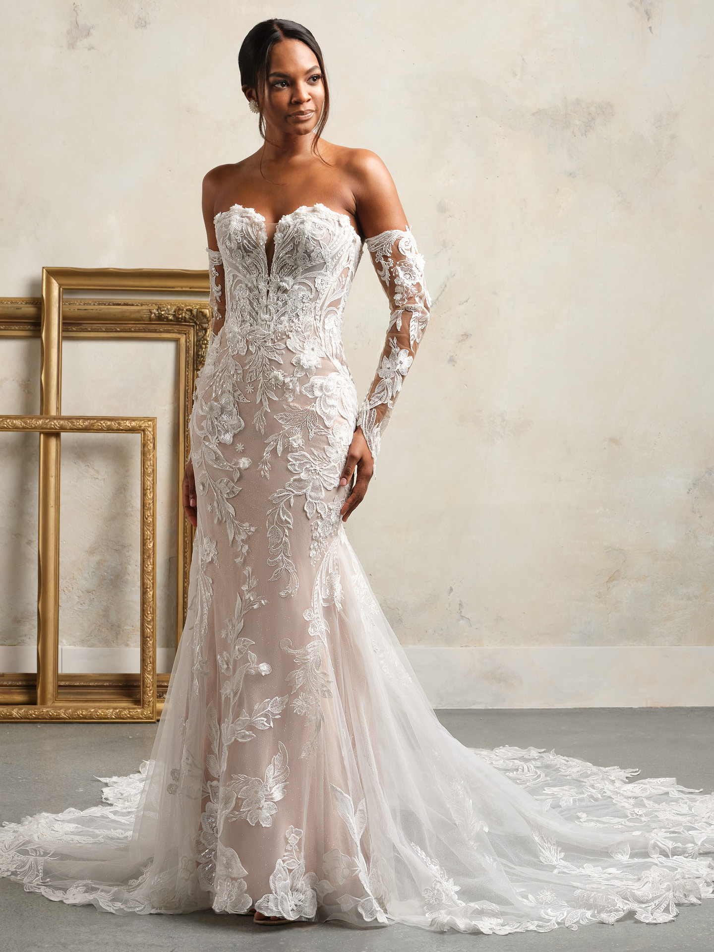 Bride wearing Nyjah by Sottero and Midgley, a fit-and-flare lace wedding dress with illusion bodice, deep sweetheart neckline, detachable lace sleeves, and soft tulle train.