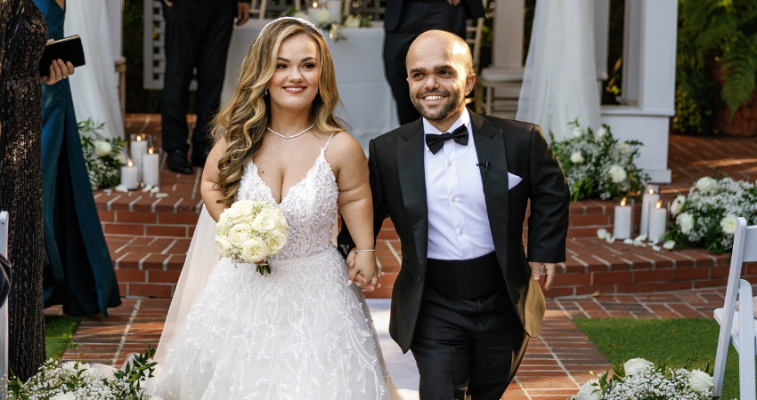 Lona in an A-line wedding dress with her husband, Sam, on their wedding day.